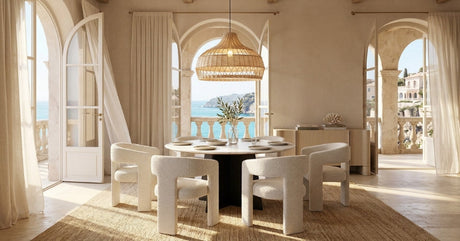 Bright coastal space with an OROA dining table, upholstered chairs, and arched windows.